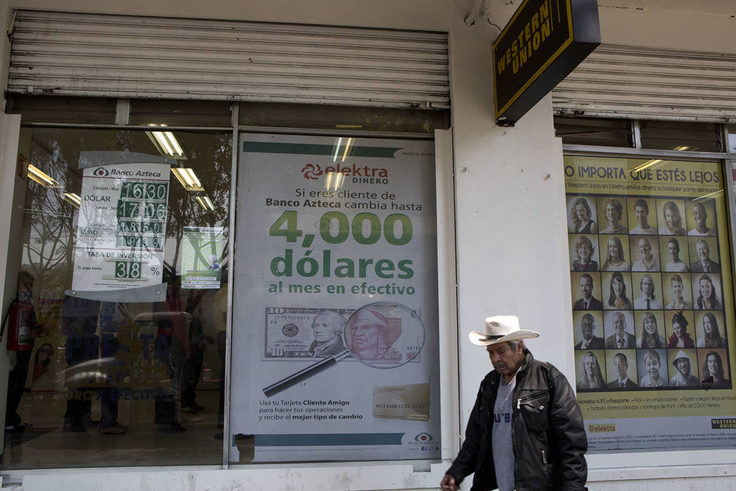 Un hombre recorre los carteles anunciando servicios de transferencia de dinero y préstamos fuera de un negocio en la Ciudad de México, el martes 5 de abril de 2016. El candidato republicano a la ...