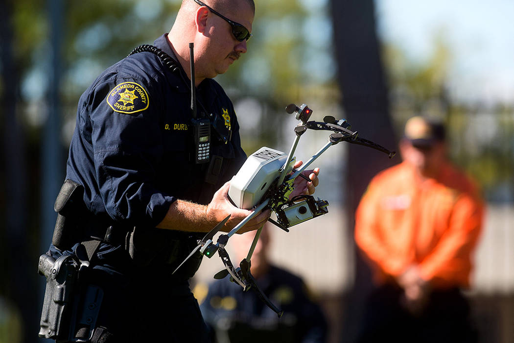 El subdirector del Sheriff del Condado de Alameda Dave Durbin, izq., opera un drone mientras demuestra una operación de búsqueda y rescate, el viernes 14 de agosto de 2015 en Dublín, California ...