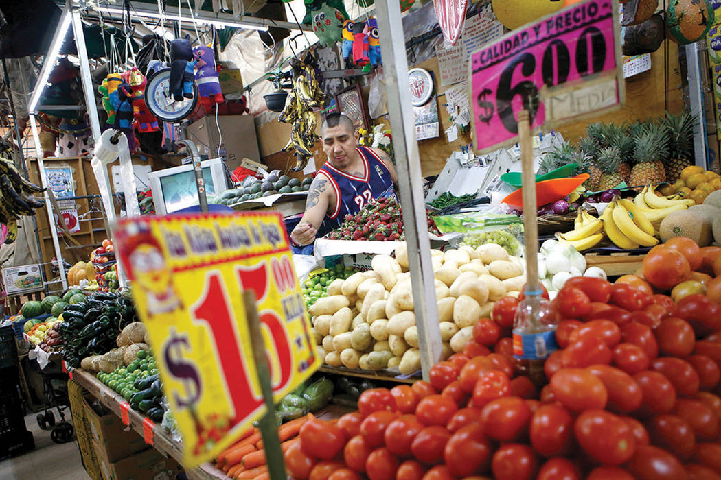 El comerciante Luis Alberto Bautista acomoda una fresas al inicio del día en su puesto de verduras en el Mercado Medellín en la Ciudad de México, el jueves 2 de febrero de 2017. México es el p ...