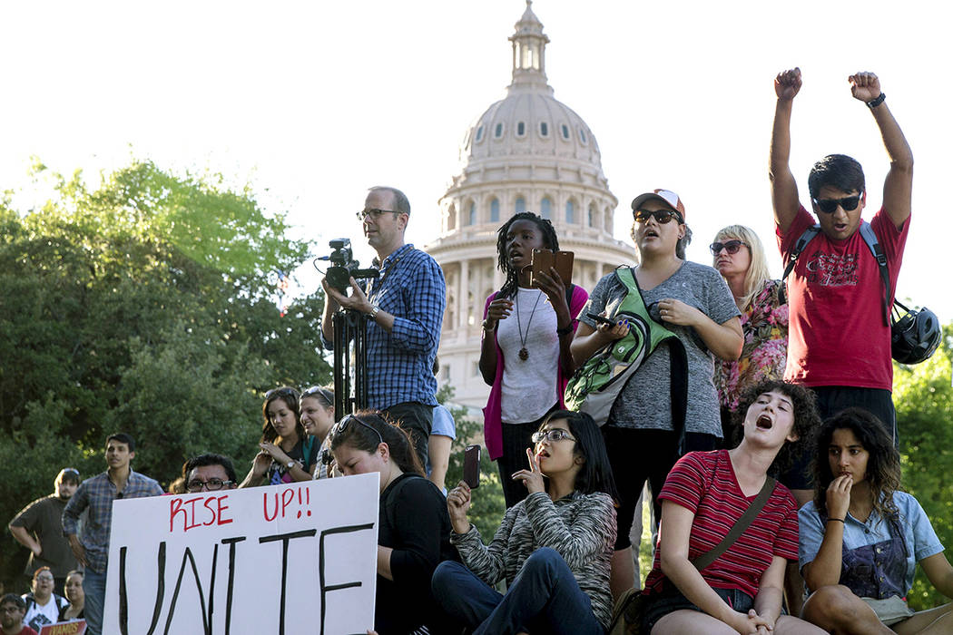 En esta foto del 1 de mayo de 2017, los manifestantes en contra del proyecto de ley del Senado 4 ciudades del santuario se reúnen fuera del edificio del Departamento de Seguros de Texas donde el  ...