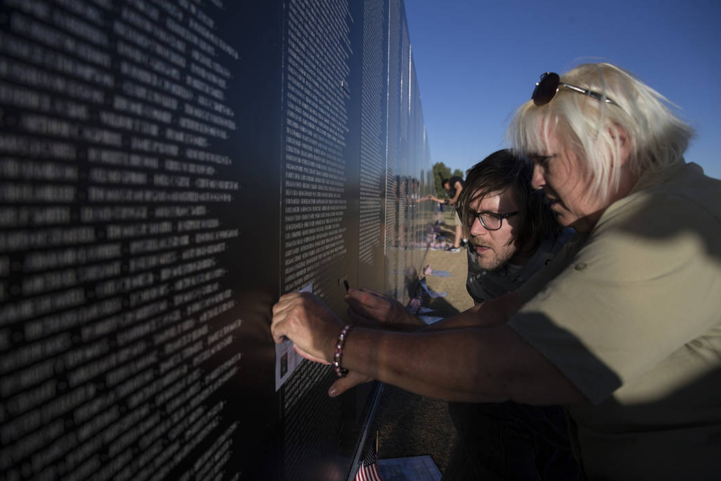 El veterano del Ejército de los Estados Unidos, Gayle "Stormy" Patrick, con su hijo Jordan Meyers, grabó el nombre de su tío en la réplica de la muralla conmemorativa de los Veteranos de Vietn ...