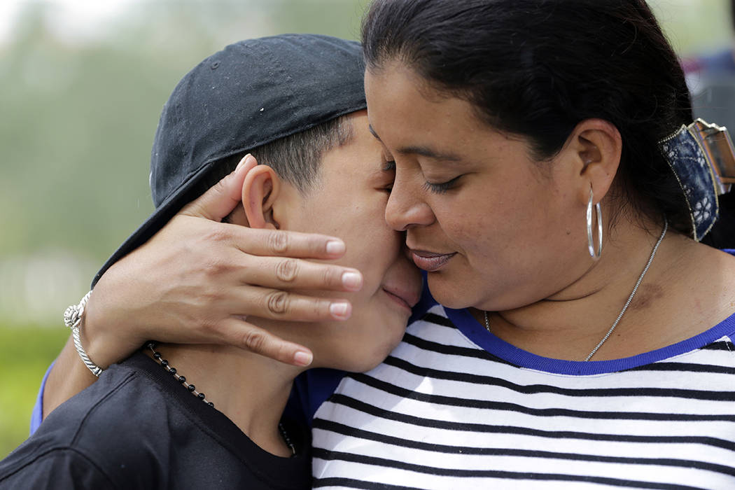William Martínez, de 11 años, es abrazado por su madre Jenny Martínez durante una manifestación fuera del Servicio de Ciudadanía e Inmigración de Estados Unidos (USCIS), el viernes 19 de may ...