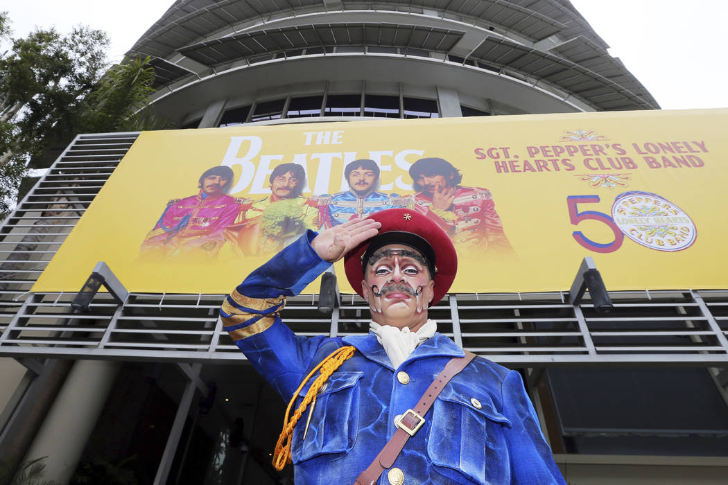 Un actor del Cirque du Soleil que retrata al Sgt. Pepper saluda después de levantar una bandera conmemorativa en el 50 aniversario del clásico álbum de los Beatles, "Sgt. Pepper's Lonely Hearts ...