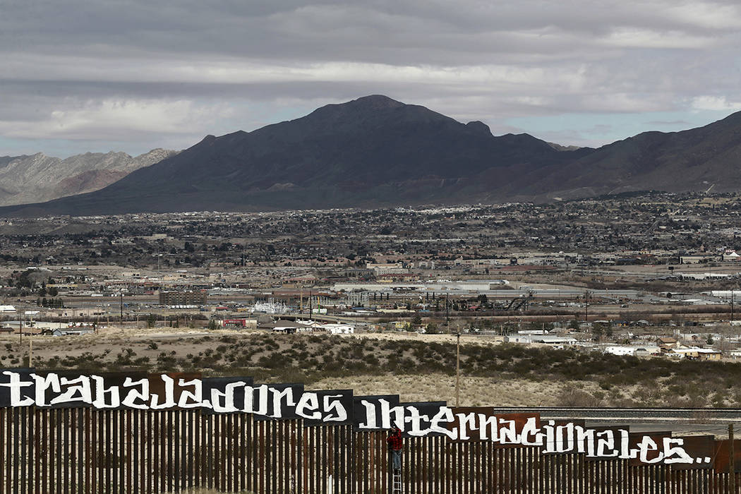 Sunland Park, Nuevo México, es visto por encima de la valla fronteriza de Estados Unidos cuando un manifestante termina de pintar el lema español "Ni los delincuentes ni los ilegales, nosotros s ...