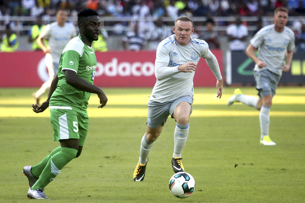 El delantero del Everton Wayne Rooney, a la derecha, corre con la pelota por delante de los defensores de Gor Mahia durante su amistoso partido de fútbol en el estadio nacional de Dar es Salaam e ...