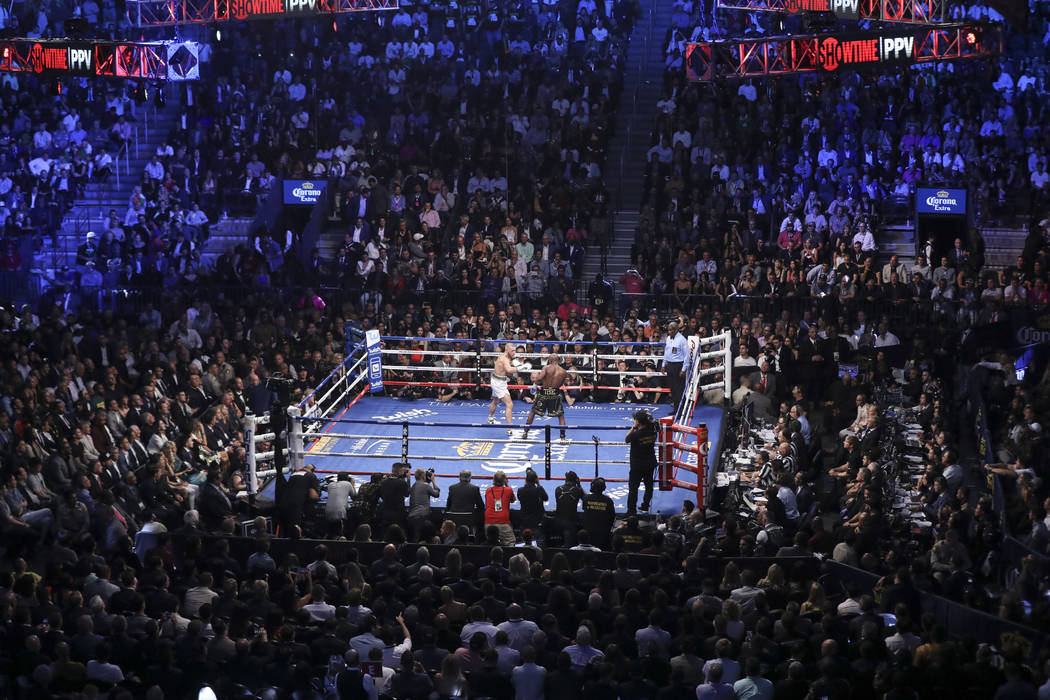 Conor McGregor, a la izquierda, pelea a Floyd Mayweather Jr. en su pelea por superpesos en el T-Mobile Arena, el sábado 26 de agosto de 2017, en Las Vegas. Mayweather ganó a través de la 10 ª  ...
