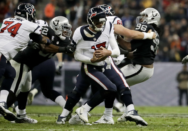 Khalil Mack (52), defensa de los Oakland Raiders sujeta por el brazo al quarterback  Brock Osweiler de los Houston Texans en la primera mitad del juego de fútbol americano de la NFL el 21 de novi ...