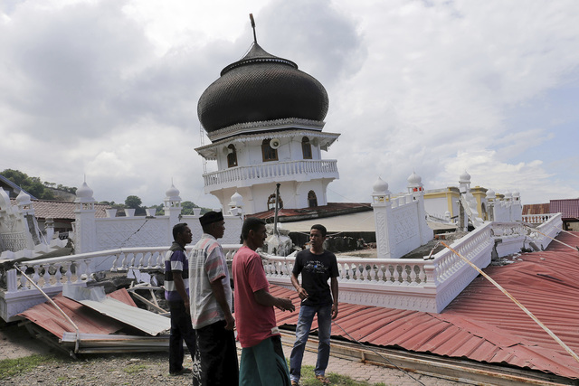 Unos hombres inspeccionan la estructura de una mesquita colapsada durante un terremoto en Pidie Jaya, Aceh provincia de Indonesia, la mañana del 7 de diciembre del 2016. (AP Photo/Heri Juanda).