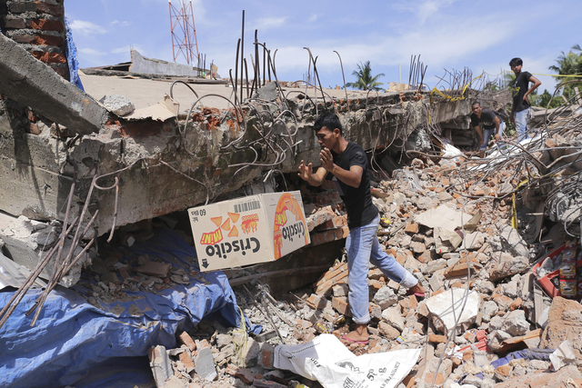 Un hombre remueve cosas de los escombros de un edificio derrumbado por un potente terremoto ocurido el miércoles 7 de diciembre del 2016 en Pidie Jaya, Aceh, provincia de Indonesia. (Heri Juanda/AP).