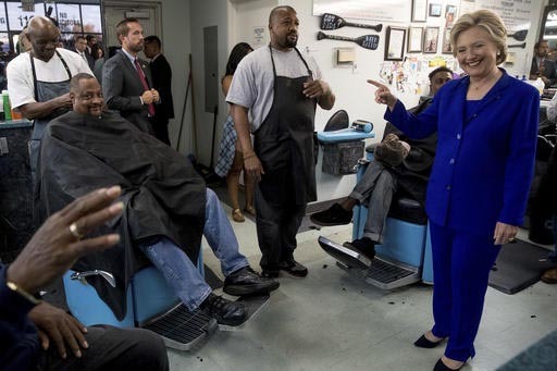 La candidata demócrata a la presidencia, Hillary Clinton, habla con clientes en la peluquería "Love's Barbershop" en North Las Vegas, Nev., el dos de noviembre del 2016. (AP Photo/Andrew Harnik).