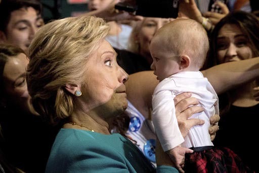 La candidata presidencial demócrata Hillary Clinton sostiene un bebé cuando saluda a los asistentes en un evento de campaña en el Colegio Estatal Palm Beach, en Lake Worth, Fla., el 26 de octub ...
