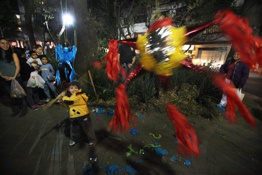 En esta foto de archivo, de diciembre 19 del 2013, un niño trata de romper una piñata en un barrio de la Ciudad de México. Las piñatas son parte de "Las Posadas", que empiezan el 16 de diciemb ...
