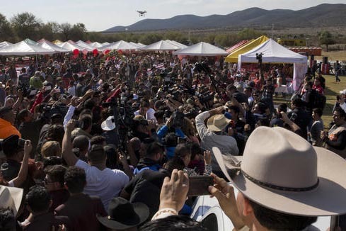 Una multitud sigue desde lejos el servicio religioso en honor de la quinceañera Rubi Ibarra, además rodeada por una horda de periodistas, en "La Joya", San Luis Potosí, México, el lunes 26 de  ...