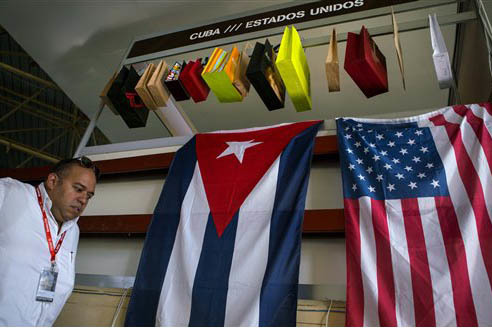 En esta foto de archivo, del 2 de noviembre del 2015, un hombre camina junto a las banderas de Cuba y de Los Estados Unidos, en un evento en La Habana, Cuba. Ahora el 12 de enero del 2017 se dio a ...