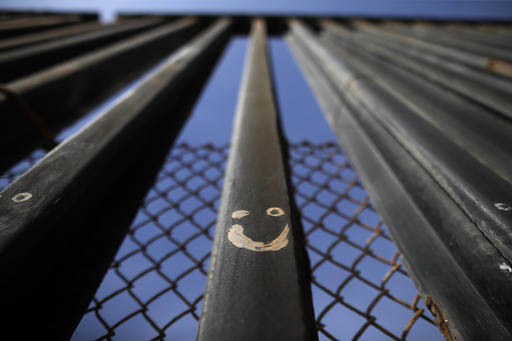 Una figura de Graffitti se ve pintada en las barras de acero que marcan y separan la frontera de Mexico con los Estados Unidos, en donde empieza el Océano Pacifico, del lado de Tijuana, en foto a ...