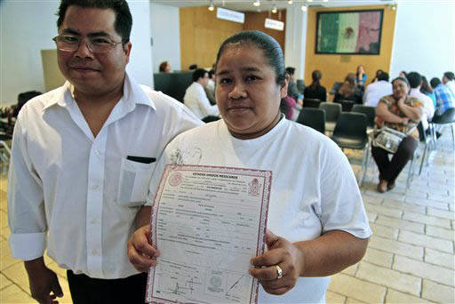 En esta foto de archivo, del 31 de mayo del 2012, Jaime García aparece con su novia Esther Bautista, quien sostiene su acta de nacimiento que recibió después de 37 años, en el Consulado de Mé ...