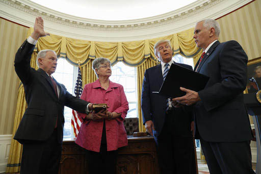 El Presidente Donald Trump observa al VicePresidente Mike Pence cuando administra el juramento a Jeff Sessions como nuevo Abogado General de los Estados Unidos, quien jura al lado de su espoa Mary ...