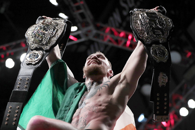 Conor McGregor sostiene sus cinturones después de derrotar a Eddie Alvarez durante un combate de artes marciales mixtas de peso ligero en el UFC 205, el domingo 13 de noviembre de 2016, en el Mad ...