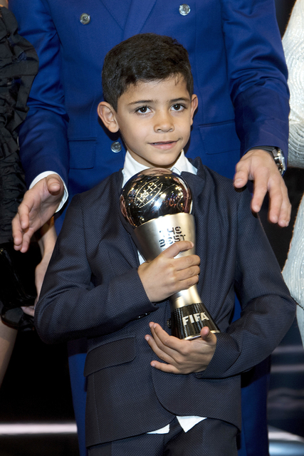 Cristiano Ronaldo Junior lleva el trofeo a su padre, Cristiano Ronaldo, de Portugal, jugando para el Real Madrid, ganó el premio al Mejor Jugador Masculino de la FIFA durante la ceremonia de los  ...