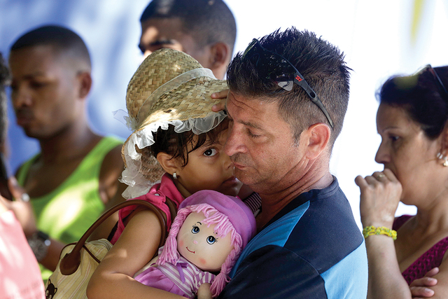 Cuban migrant Denis Gomez, 45, hold up his daughter Dalia Caridad, 4, during a meeting at a shelter in Panama City, Friday, Jan. 13, 2017. President Barack Obama announced Thursday he is ending a  ...