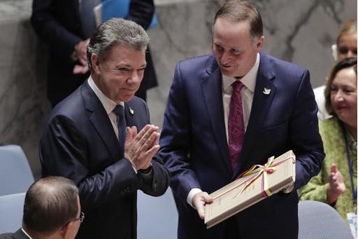 Juan Manuel Santos (izquierda) presidente de Colombia, entregó una copia del acuerdo de paz con los rebeldes de las FARC en su país, a John Key, presidente de Nueva Zelanda y presidente del Cons ...