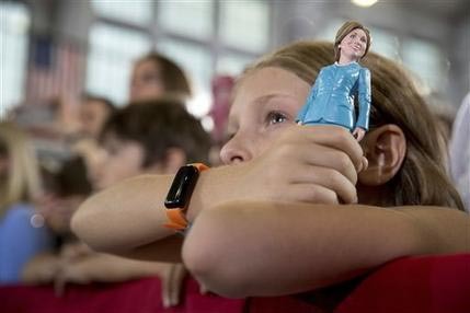 Una niña sostiene una muñeca de la candidata presidencial demócrata Hillary Clinton, quien habla en un acto en Akron, Ohio, 3 de octubre de 2016. (AP Foto/Andrew Harnik).