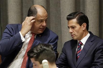 El presidente de México Enrique Peña Nieto (der) conversa con su colega costarricense Luis Guillermo Solís durante la Cumbre de Refugiados y Migrantes de la ONU el 19 de septiembre del 2016. (A ...
