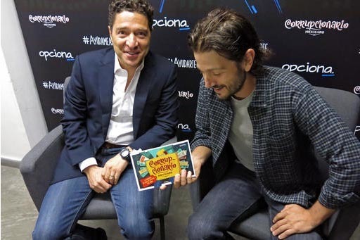 El actor mexicano Diego Luna, a la derecha, y el activista Alejandro Legorreta, de la organización "NGO Opciona" muestran una copia del libro titulado “Corrupcionario”, el 27 de septiembre de ...
