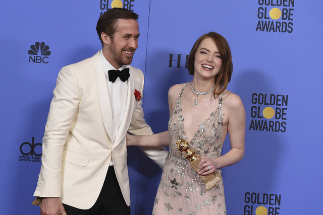 Ryan Gosling, a la izquierda, y Emma Stone posan en la sala de prensa con el premio a la mejor actuación de un actor y actriz en un cine - musical o comedia en la entrega Anual 74 de los Golden G ...