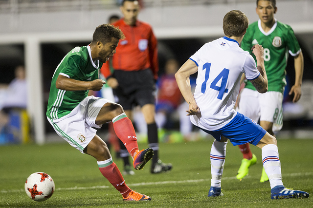 El mexicano Giovani Dos Santos (10) hace un pase bajo presión de Bodvar Bodvarsson (14) de Islandia en el partido de la exposición del fútbol en el estadio de Sam Boyd el miércoles 8 de febrer ...