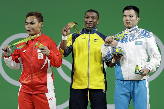 Oscar Albeiro Figueroa Mosquera de Colombia ganó la medalla de oro, centro, Eko Yuli Irawan de Indonesia, obtuvo medalla de plata, izq. y Farkhad Kharki de Kazakhstan, ganó la medalla de bronce, ...