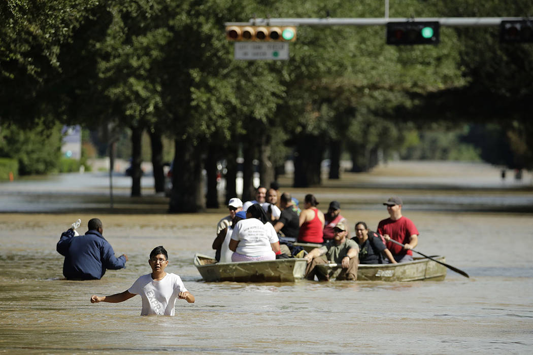 Gente evacua un vecindario inundado después de que el agua fuera liberada del cercano embalse de Addicks cuando alcanzó su capacidad debido a la tormenta tropical Harvey. Miércoles 30 de agosto ...