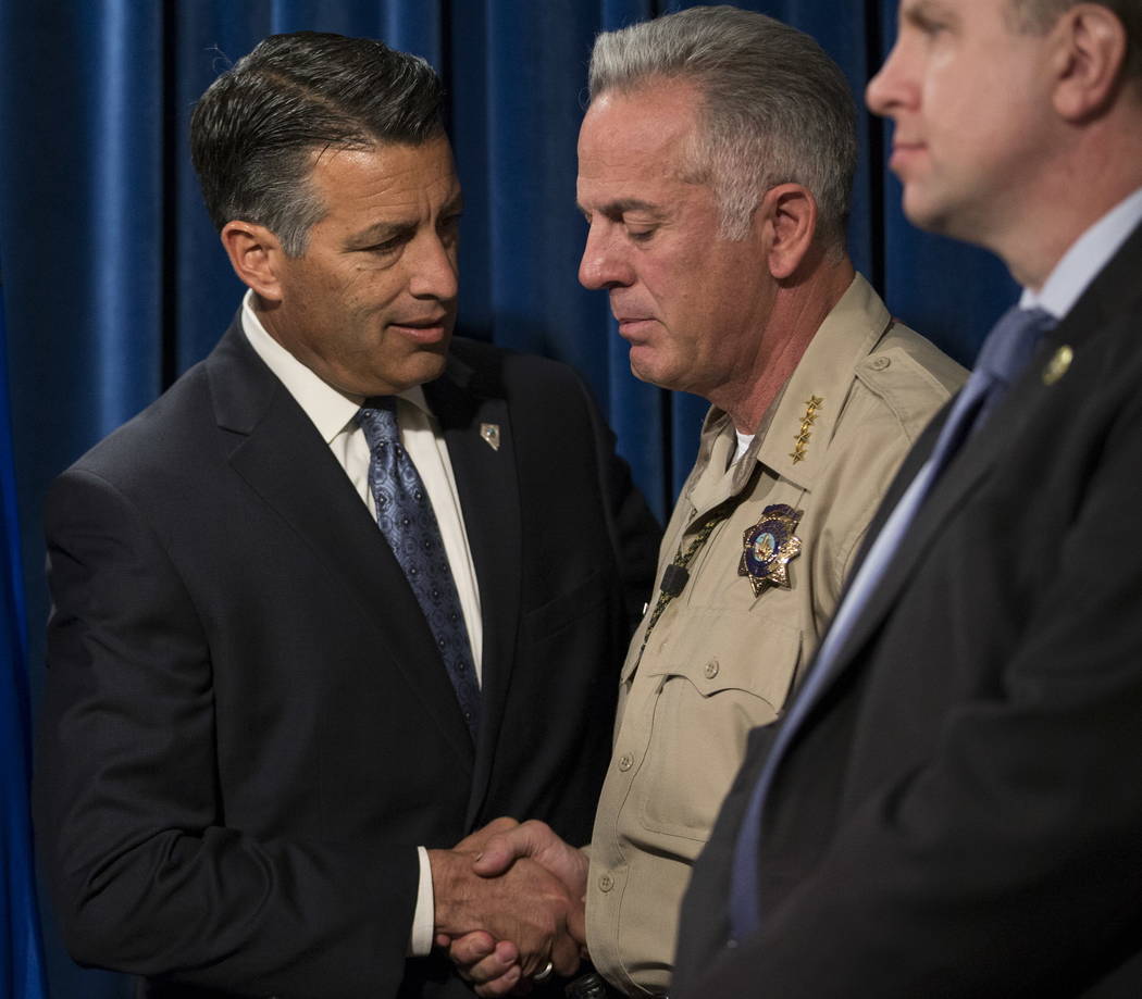 El Gobernador Brian Sandoval, a la izquierda, y el Sheriff del Condado de Clark Joe Lombardo durante una conferencia de prensa sobre el tiroteo masivo, en el cuartel general del Departamento de Po ...