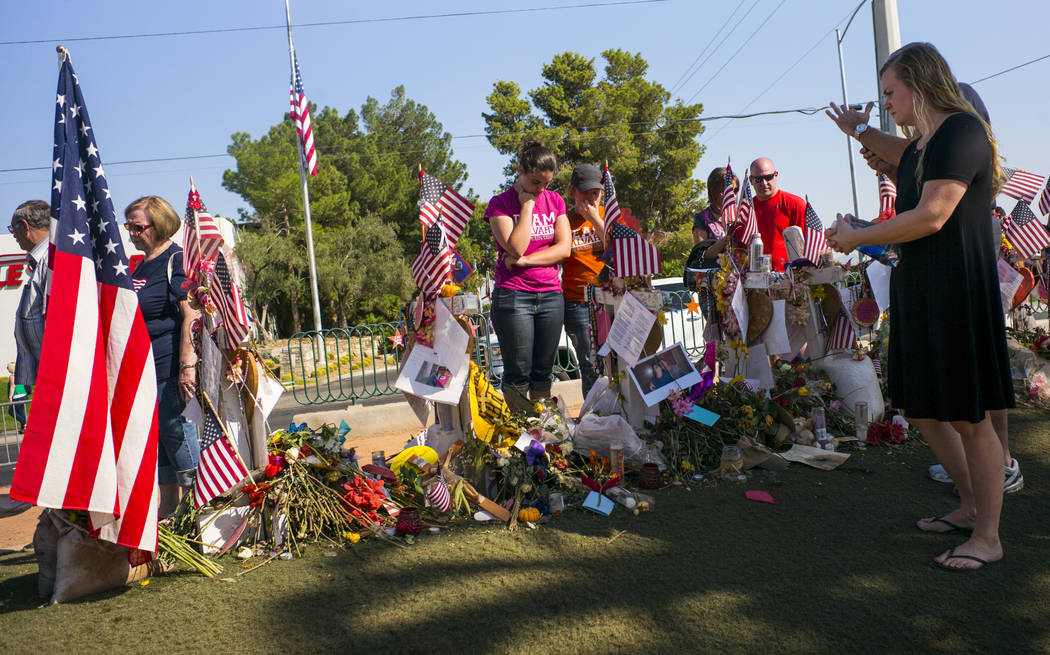 La gente visita las cincuenta y ocho cruces dejadas en honor de las víctimas del tiroteo masivo en un monumento improvisado cerca del letrero de "Bienvenido a Fabuloso Las Vegas" en Las Vegas el  ...