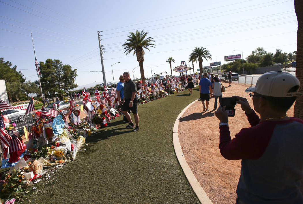 La gente visita las cincuenta y ocho cruces dejadas en honor de las víctimas en el tiroteo masivo en un monumento improvisado cerca del letrero de "Bienvenido a Fabuloso Las Vegas" en Las Vegas e ...
