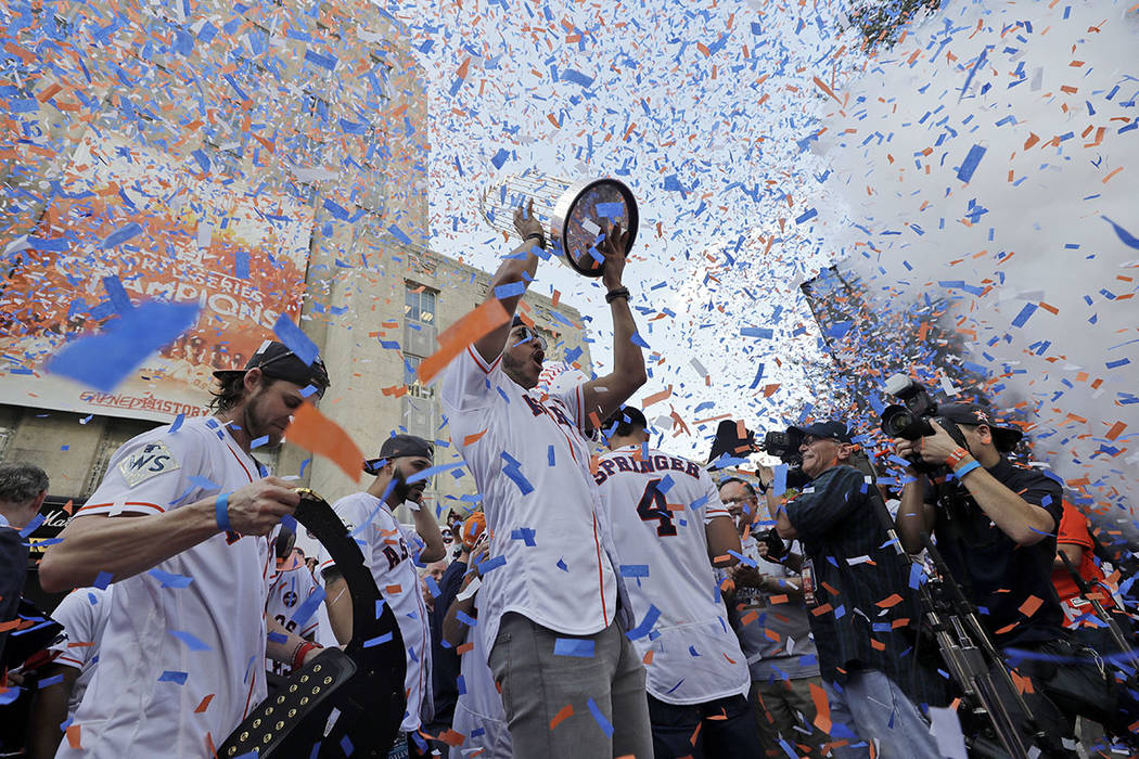 Carlos Correa de los Astros de Houston levanta el trofeo del campeonato mientras celebra con sus compañeros durante un mitin en honor a los campeones de la Serie Mundial de béisbol el viernes 3  ...