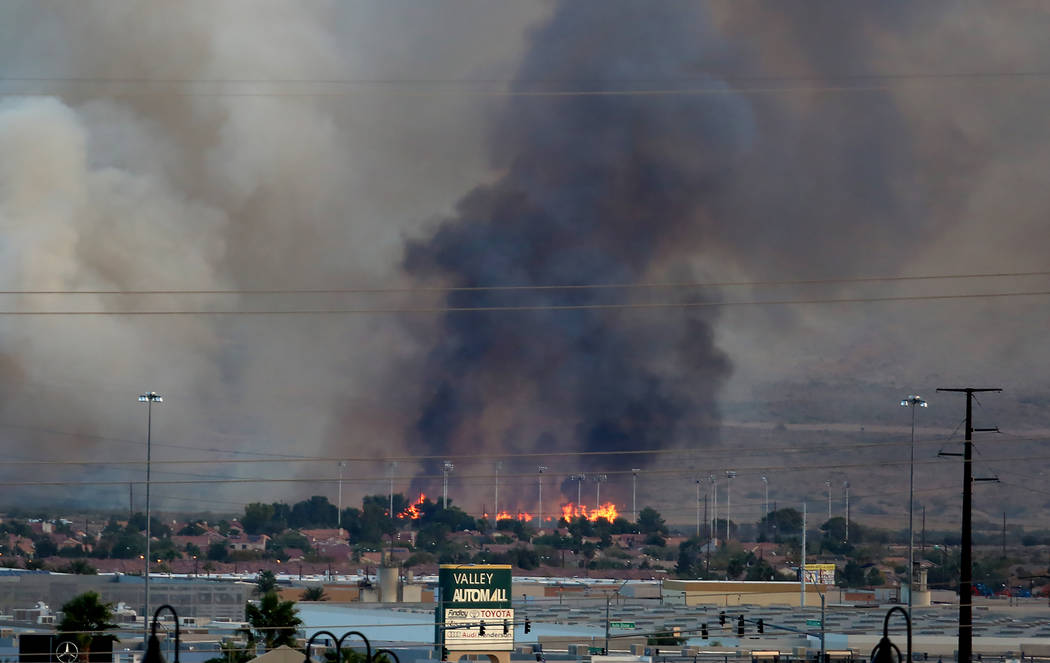El humo y las llamas son visibles en el Clark County Wetlands Park, cerca del estadio Sam Boyd, el lunes 6 de noviembre de 2017 en Las Vegas. El fuego abarca alrededor de 3-5 hectáreas en una par ...