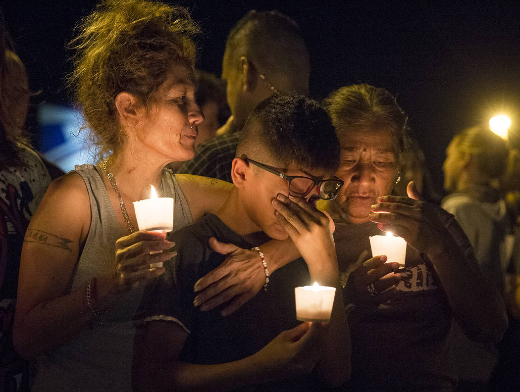 Mona Rodríguez sostiene a su hijo de 12 años, J Anthony Hernández, durante una vigilia con velas para las víctimas de un tiroteo fatal en la Primera Iglesia Bautista de Sutherland Springs, el  ...