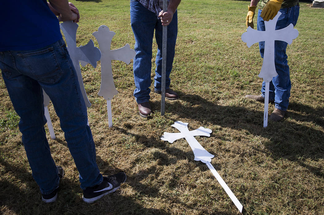 Doug John, al centro, clava una estaca en el suelo antes de erigir una cruz en memoria de una de las 26 personas asesinadas en Sutherland Springs, el lunes 6 de noviembre de 2017. El tiroteo tuvo  ...