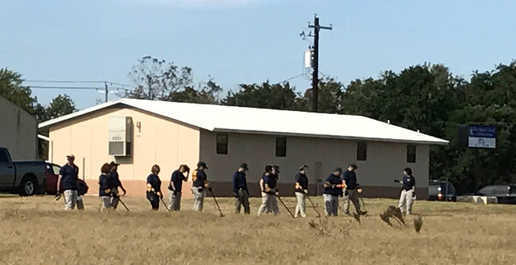 Los agentes del FBI usan detectores de metales en busca de evidencia cerca de la iglesia en Sutherland Springs, Texas. Foto de Gary Martin
