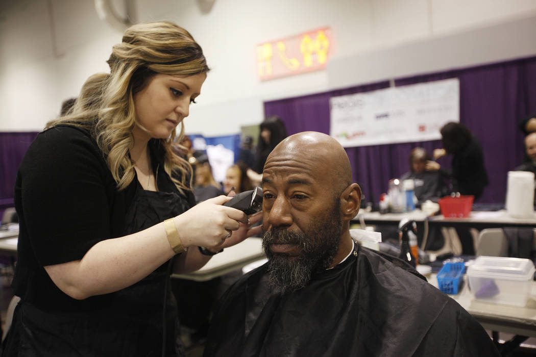 Sheila Rees recorta la barba de Brigham Roberts en Project Homeless Connect, una feria de servicios y recursos para personas sin hogar o en riesgo en el Cashman Center de Las Vegas, el martes 14 d ...