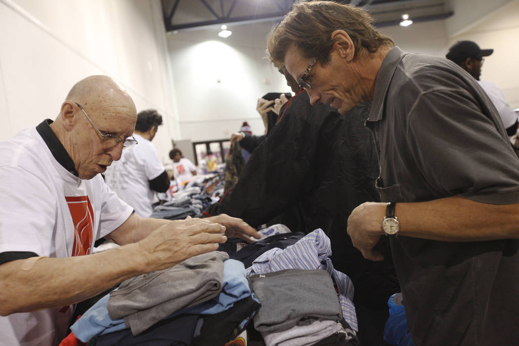 El voluntario Bill Corzatt, izquierda, ayuda a Lawrence Green a buscar pantalones en Project Homeless Connect, una feria de servicios y recursos para personas sin hogar o en riesgo en el Cashman C ...