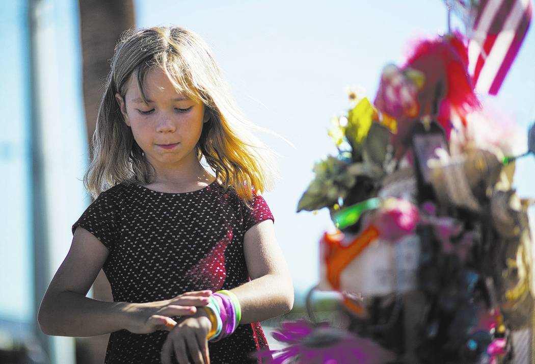 Brooke Patterson, de Lomita, Calif., De siete años, visita un monumento improvisado para su madre, Lisa Patterson, quien fue una de las 58 personas que murieron en el tiroteo del 1° de octubre e ...