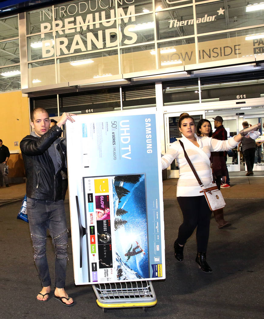 Louis Tamarit, izquierda, y Luisa Puentes salen con su compra de TV de pantalla plana a las 12:42 a.m. después de las compras del Black Friday en Best Buy en Henderson el 24 de noviembre de 2017, ...