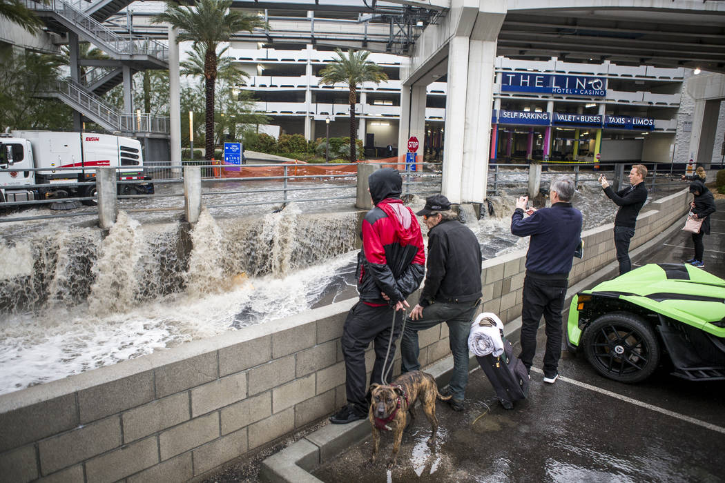 La gente mira las aguas de las inundaciones apresurarse en un canal pluvial cerca del Hotel The Linq en Las Vegas el martes 9 de enero de 2018. (Patrick Connolly / Las Vegas Review-Journal) @PConnPie