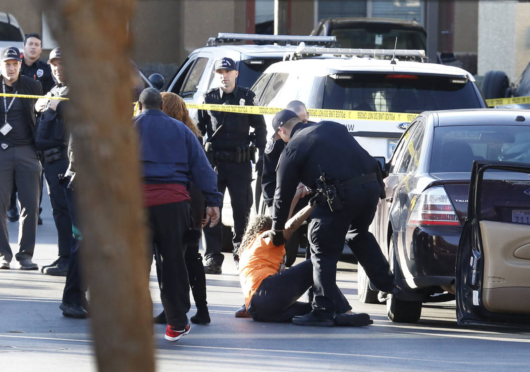 Un oficial de policía de North Las Vegas consuela a un familiar no identificado de las víctimas del tiroteo donde la policía investiga un tiroteo mortal el 2 de febrero de 2018 en Colonial Gran ...