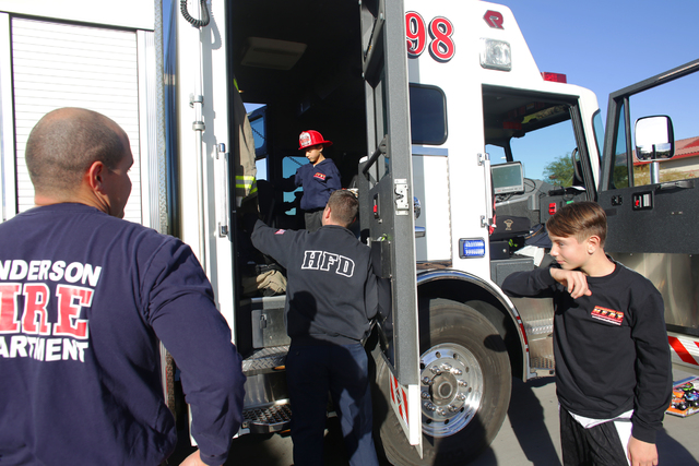 El bombero Donovan Kutsenda le da a Edward Angulo, de 6 años, y Chance Harridge, de 12, un recorrido por el camión de bomberos en la Estación de Bomberos 98, el martes 20 de diciembre de 2016,  ...