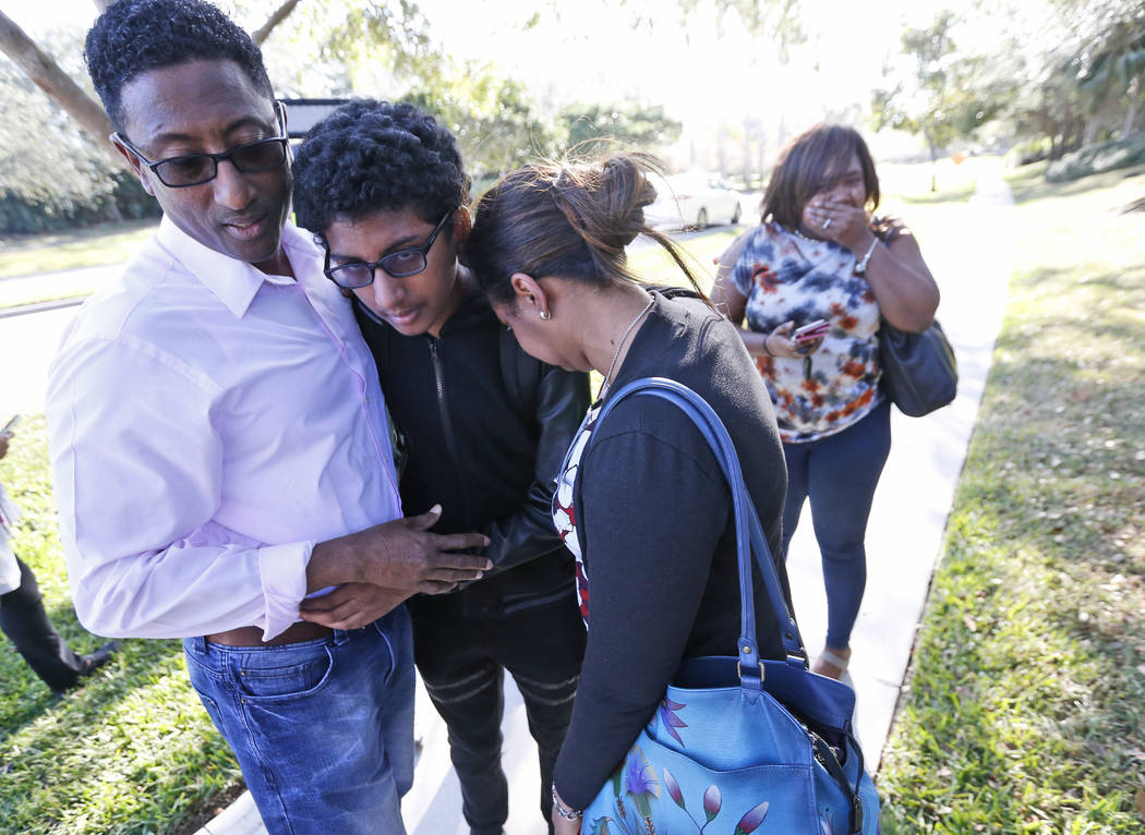 Los familiares se abrazan después de que algún estudiante saliera de Marjory Stoneman Douglas High School el miércoles 14 de febrero de 2018 en Parkland, Florida. Los disparos en la escuela sec ...