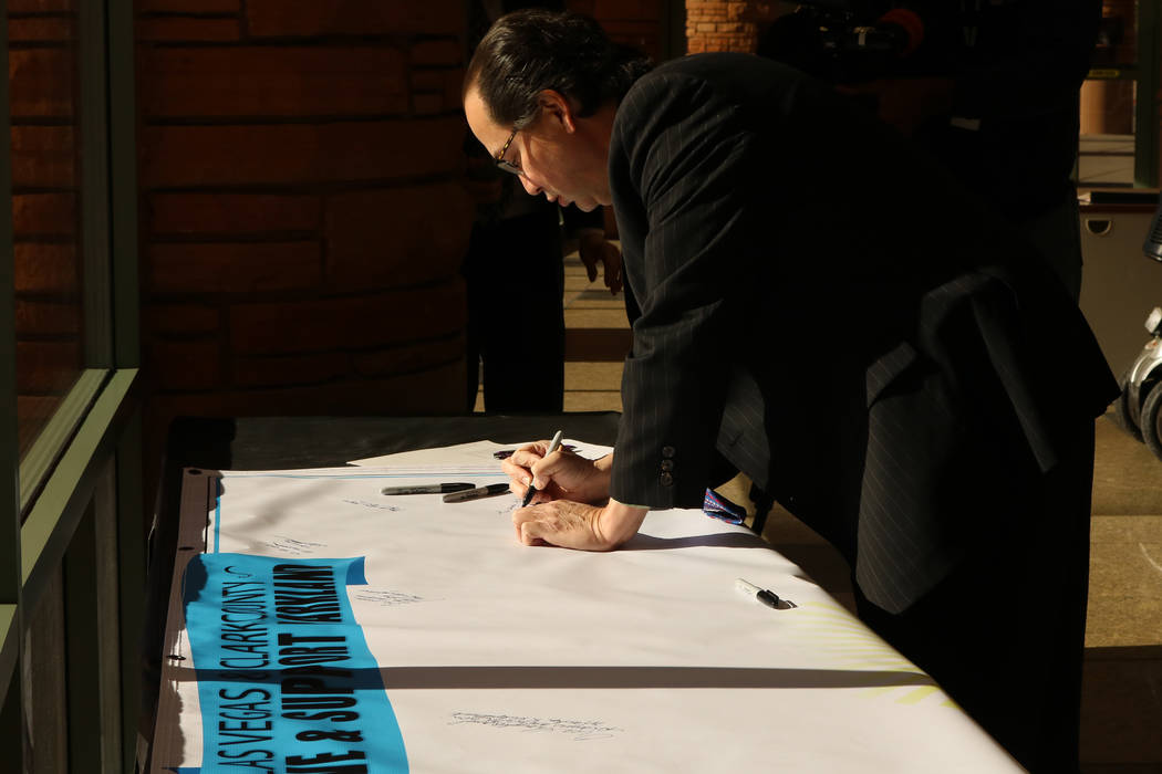 Thomas Chee signs a banner for Parkland, Fla. residents at the Clark County Government Center in Las Vegas, Tuesday, Feb. 20, 2018.  A school shooting left 17 dead in Parkland, Fla. on Feb. 1 ...
