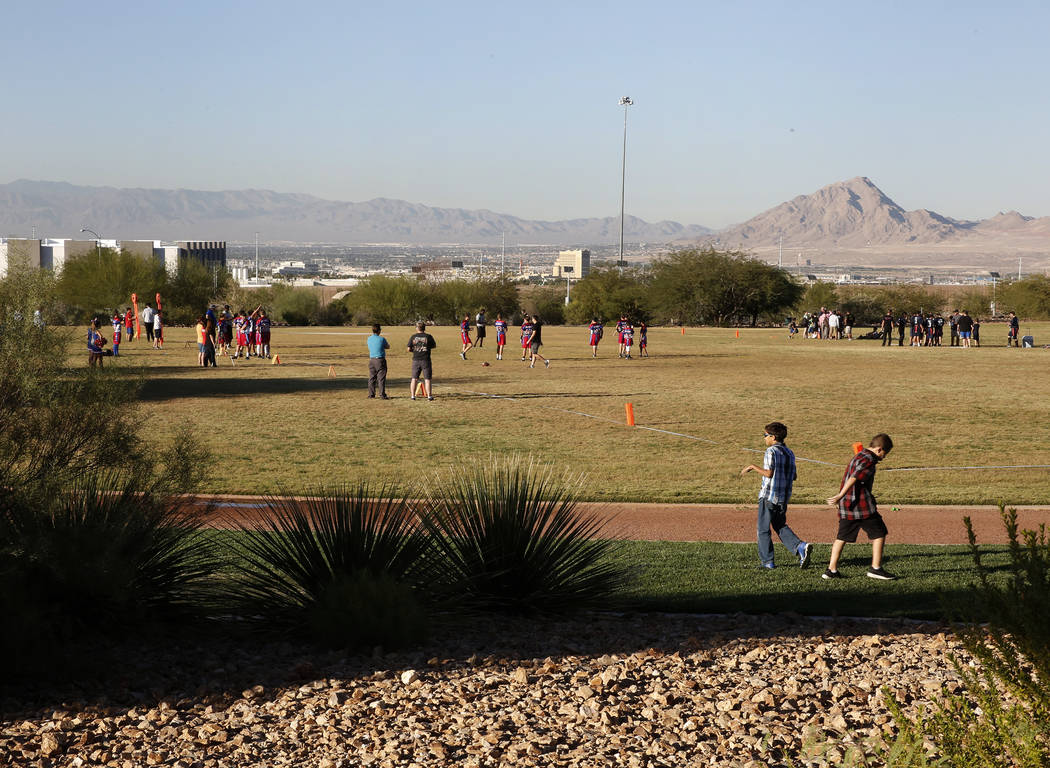 Los niños juegan fútbol americano en el campo detrás de Reunion Trails Park el jueves, 26 de octubre de 2017, en Henderson. La ciudad de Henderson y el Distrito del Condado de Clark están en d ...